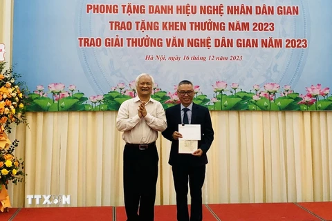 Giáo sư-Tiến sỹ Lê Hồng Lý, Chủ tịch Hội Văn nghệ dân gian Việt Nam, trao giải Nhì A cho tác giả có công trình đạt giải. (Ảnh: Phương Hà/TTXVN )