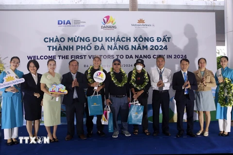 Tặng hoa, quà chúc mừng các du khách đầu tiên đến Đà Nẵng trong dịp Tết Dương lịch 2024 tại Sân bay Quốc tế Đà Nẵng. (Ảnh: Trần Lê Lâm/TTXVN)