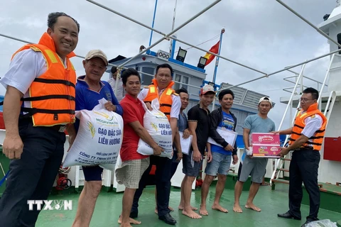 Các chiến sỹ hải quân công tác trên huyện đảo Trường Sa hỗ trợ lương thực, thực phẩm cho ngư dân Bình Thuận. (Ảnh: TTXVN phát)