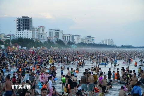 Các bãi biển ở thành phố Sầm Sơn đông người dân, du khách đi tắm biển. (Ảnh: Hoa Mai/TTXVN)