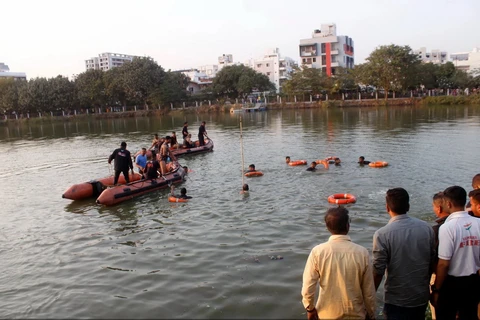Lực lượng cứu hộ tìm kiếm học sinh mất tích sau khi chiếc thuyền chở 27 người bị lật ở bang Gujarat, miền Tây Ấn Độ, ngày 18/1. (Nguồn: AP)