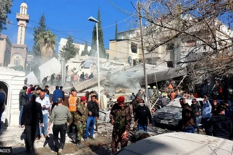 Người dân và lực lượng an ninh tập trung trước một tòa nhà bị phá hủy trong vụ nổ ở Damascus ngày 20/1. (Nguồn: Getty Images)