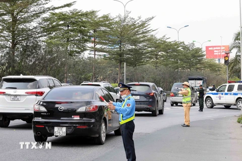 Lực lượng chức năng lập "hàng rào sống" phân luồng, điều tiết giao thông tại cao tốc Pháp Vân-Cầu Giẽ hướng vào trung tâm Hà Nội. (Ảnh: Phạm Kiên/TTXVN)