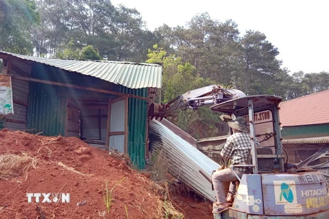 Lực lượng chức năng cưỡng chế, tháo dỡ các trường hợp xây dựng nhà, lều tạm trên đất rừng ven đường Hồ Chí Minh, đoạn qua xã Nâm N’jang, huyện Đắk Song, tỉnh Đắk Nông. (Ảnh: TTXVN phát)