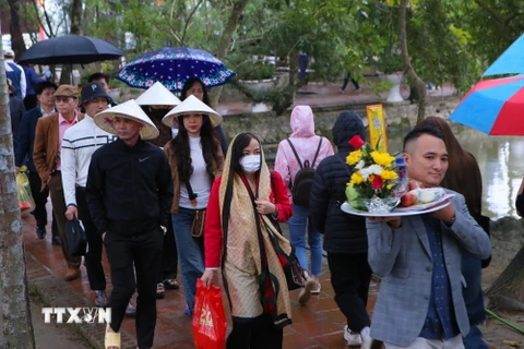Mặc dù trời mưa nhẹ nhưng chiều tối ngày 14 tháng Giêng đông đảo du khách đến đền Trần để tham quan, vãn cảnh. (Ảnh: Công Luật/TTXVN)