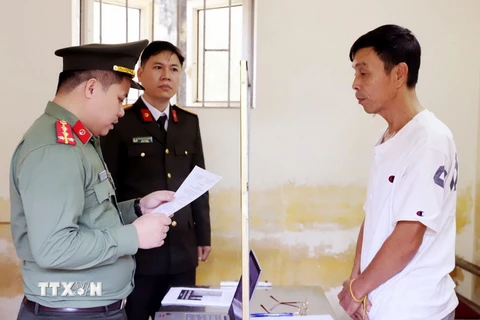 Công an đọc lệnh bắt tạm giam Phan Đình Sang. (Ảnh: TTXVN phát)