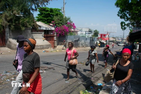 Người dân chạy trốn khỏi khu vực xảy ra đụng độ ở Port-au-Prince, Haiti ngày 20/3 vừa qua. (Ảnh: AFP/TTXVN)