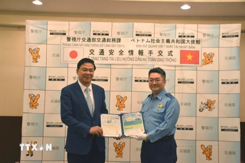 Đại diện Sở Cảnh sát Tokyo đã trao tặng Tài liệu hướng dẫn an toàn giao thông cho Đại sứ Việt Nam tại Nhật Bản Phạm Quang Hiệu. (Ảnh: Nguyễn Tuyến/TTXVN)
