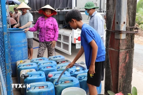 Người dân đến lấy nước tại điểm cấp nước tại ấp Pháo Đài, xã Phú Tân. (Ảnh: Minh Trí/TTXVN)