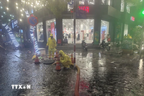 Lực lượng, phương tiện của Công ty TNHH Một thành viên Thoát nước Hà Nội ứng trực thoát nước trên phố Bà Triệu vào chiều tối 30/5 vừa qua. (Ảnh: TTXVN phát)