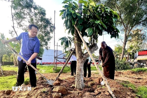 Lãnh đạo Thành ủy, UBND thành phố Thủ Dầu Một, tỉnh Bình Dương tham gia trồng cây ăn quả phủ xanh đất công để tạo công viên. (Ảnh: TTXVN phát)