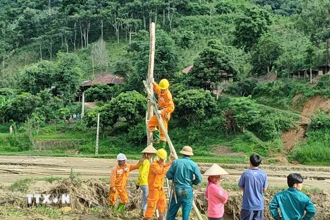 Công nhân Điện lực khu vực Mai Sơn-Yên Châu thuộc Công ty Điện lực Sơn La, nỗ lực khôi phục lại hệ thống điện cho 149 hộ dân bản Nhụng Trên, xã Chiềng Nơi. (Ảnh: TTXVN phát)