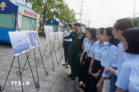 Đại diện Hội nhiếp ảnh Thành phố Hồ Chí Minh giới thiệu về bộ ảnh “Yêu lắm Trường Sa ơi!” tới khách tham quan. (Ảnh: Thu Hoài/TTXVN)