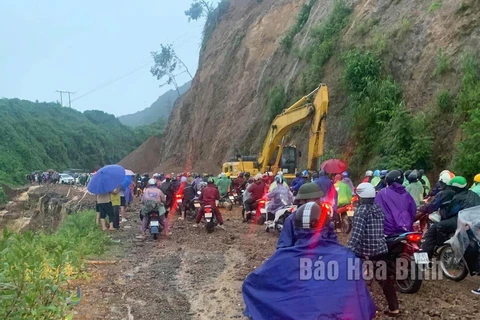 Lực lượng chức năng huy động phương tiện khắc phục sạt lở, hỗ trợ người dân lưu thông qua dốc Cun, tỉnh Hòa Bình. (Nguồn: báo Hòa Bình)