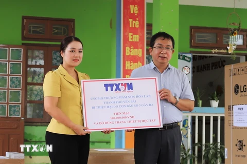 Phó Tổng giám đốc TTXVN Nguyễn Tuấn Hùng trao tặng số tiền 100 triệu đồng của TTXVN hỗ trợ Trường Mầm non Hoa Lan, phường Hồng Hà, thành phố Yên Bái khắc phục thiệt hại của bão số 3. (Ảnh: Tiến Khánh/TTXVN)