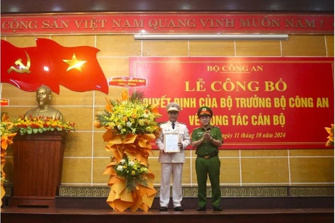 Trung tướng Nguyễn Văn Long (bên phải), Thứ trưởng Bộ Công an trao quyết định và tặng hoa chúc mừng Đại tá Nguyễn Thanh Liêm. (Nguồn: VOV)