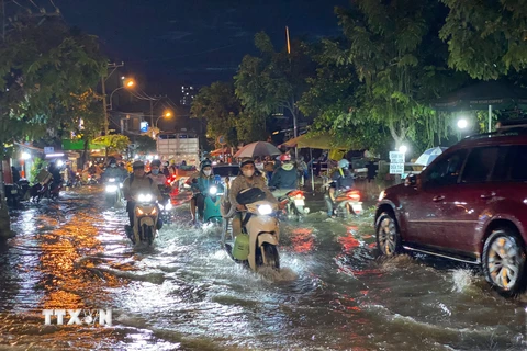 Các phương tiện di chuyển khó khăn khi triều cường gây ngập trên đường Trần Xuân Soạn, quận 7. (Ảnh: Hồng Giang/TTXVN)