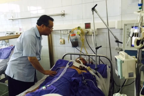 Thứ trưởng Bộ Lao động-Thương binh và Xã hội Huỳnh Văn Tí thăm hỏi nạn nhân bị tai nạn. (Ảnh: PV/Vietnam+)