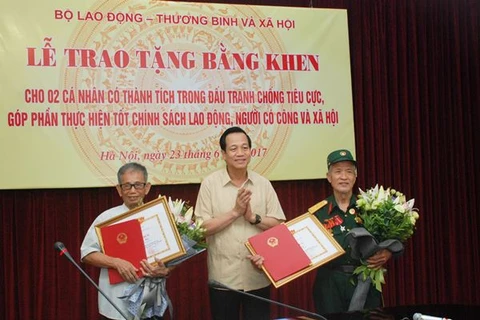 Bộ trưởng Đào Ngọc Dung tặng bằng khen cho hai lão nông ở Bắc Ninh. (Ảnh: PV/Vietnam+)