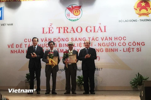Bộ trưởng Bộ Lao động-Thương binh và Xã hội Đào Ngọc Dung trao giải cho các tác giải đoạt giải Nhất. (Ảnh: PV/Vietnam+)