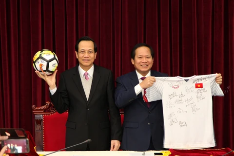 Bộ trưởng Bộ Lao động-Thương binh và Xã hội Đào Ngọc Dung và Bộ trưởng Bộ Thông tin và Truyền thông Trương Minh Tuấn nhận hai món quà sẽ đấu giá. (Ảnh: PV/Vietnam+)