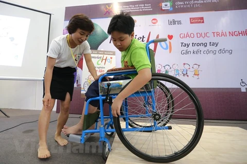 Trẻ em tham gia đóng vai người khuyết tật ngồi xe lăn để cảm nhận được những khó khăn của họ trong cuộc sống. (Ảnh minh họa: Minh Sơn/Vietnam+)