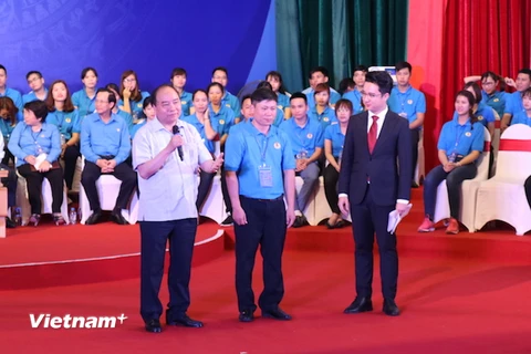 Thủ tướng trao đổi, giải đáp những ý kiến của công nhân lao động. (Ảnh: Hồng Kiều/Vietnam+) 