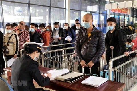 Tại cửa khẩu Móng Cái, cán bộ kiểm dịch y tế quốc tế Quảng Ninh tăng cường giám sát khách nhập cảnh. (Ảnh: TTXVN phát)