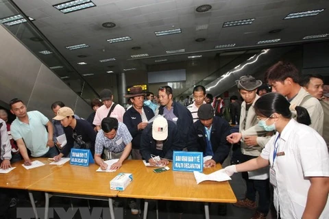 Lao động trở về từ Libya làm thủ tục kiểm dịch y tế tại sân bay Nội Bài. (Ảnh: Anh Tuấn/TTXVN)
