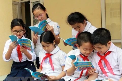 Các em học sinh đọc sách tìm hiểu về quyền trẻ em. (Ảnh minh họa: Nguyễn Thủy/TTXVN)