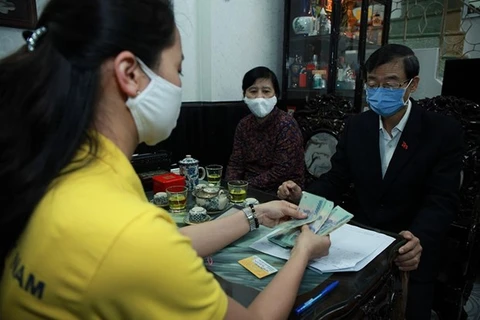 Bưu điện Thành phố Hà Nội chi trả tiền lương hưu tới tận tay người hưởng. (Ảnh: PV/Vietnam+)