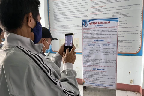 Hành khách tìm kiếm thông tin về quy định, thủ tục đổi trả vé tàu tại ga Sài Gòn. (Ảnh minh họa: Tiến Lực/TTXVN)