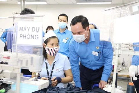 Ông Nguyễn Đình Khang, Chủ tịch Tổng Liên đoàn Lao động Việt Nam thăm hỏi công nhân lao động (Ảnh: PV/Vietnam+)