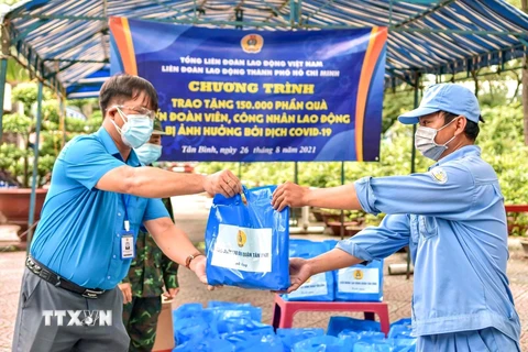 Liên đoàn Lao động Thành phố Hồ Chí Minh trao quà hỗ trợ cho công nhân, người lao động có hoàn cảnh khó khăn bị ảnh hưởng bởi dịch COVID-19. (Ảnh: Thanh Vũ/TTXVN) 