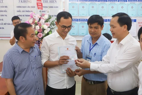 Trao giấy khai sinh và thẻ bảo hiểm y tế theo dịch vụ công liên thông giữa cơ sở dữ liệu về hộ tịch và bảo hiểm. (Ảnh minh họa: PV/Vietnam+)