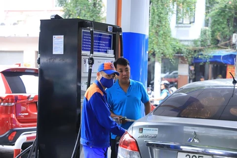 Nhân viên Petrolimex bán xăng cho khách hàng. (Ảnh minh hoạ: PV/Vietnam+)