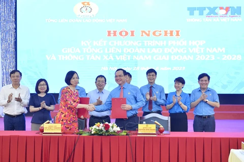 Tổng Giám đốc TTXVN Vũ Việt Trang và Chủ tịch Tổng Liên đoàn Lao động Việt Nam Nguyễn Đình Khang ký kết văn kiện phối hợp tuyên truyền giai đoạn 2023-2028. (Ảnh: Minh Đức/TTXVN)