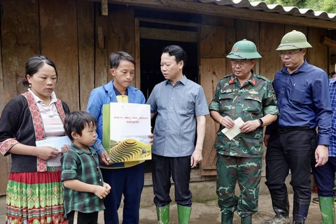 Trao quà hỗ trợ động viên gia đình bị thiệt hại trong đợt mưa lũ. (Ảnh: Tuấn Anh/TTXVN)