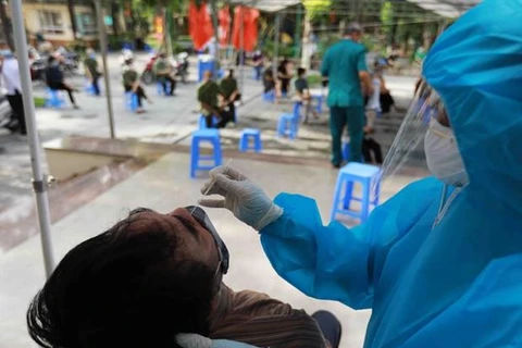Nhân viên Trung tâm Kiểm soát bệnh tật Hà Nội lấy mẫu xét nghiệm SARS-CoV-2 cho thành viên tổ COVID-19 cộng đồng trong "vùng xanh." (Ảnh: Vũ Sinh/TTXVN)