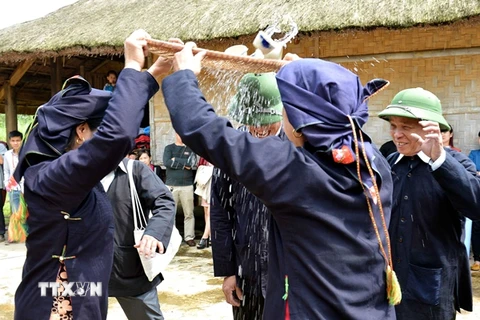 Tái hiện phong tục tưới rượu trong lễ ăn hỏi của dân tộc Sán Chay. (Ảnh minh họa: TTXVN)