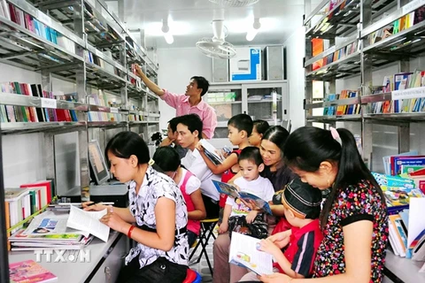Độc giả đọc sách trong xe thư viện lưu động của Thư viện tỉnh Yên Bái. (Ảnh minh họa: TTXVN)