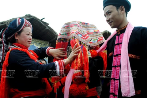 Trong đám cưới của người Dao Đỏ, cô dâu và chú rể được thắt một dải khăn tượng trưng cho sợi tơ hồng trăm năm bền chặt. (Ảnh: Báo Ảnh Việt Nam/TTXVN) 