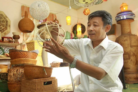 Nghệ nhân Nguyễn Văn Trung - làng nghề truyền thống Phú Vinh đang làm các sản phẩm mây tre đan. (Ảnh minh họa: TTXVN)