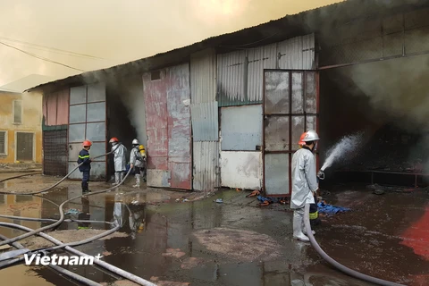 Cảnh sát tiếp tục phun nước vào hiện trường, chống cháy lan (Ảnh: Minh Sơn/Vietnam+) 