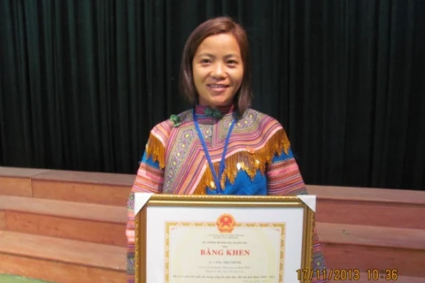 Cô Ghếnh nhận bằng khen Nhà giáo tiêu biểu giai đoạn 2008-2013. (Ảnh: Phạm Mai/Vietnam+)