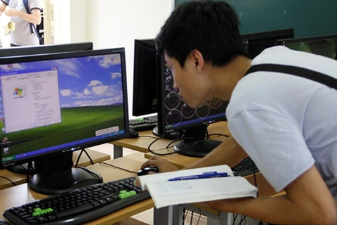 Kỹ thuật viên kiểm tra máy tính lần cuối trước khi kỳ thi bắt đầu. (Ảnh: Đại học Quốc gia Hà Nội) 