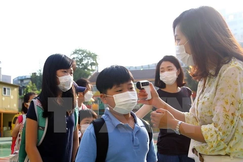 Kiểm tra thân nhiệt của các học sinh tiểu học ở thủ đô Seoul nhằm ngăn chặn lây nhiễm MERS. (Nguồn: THX/TTXVN)