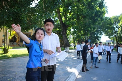 Sinh viên tình nguyện hướng dẫn thí sinh đên làm thủ tục dự thi sáng nay, 30/6. (Ảnh: Lê Minh Sơn/Vietnam+)