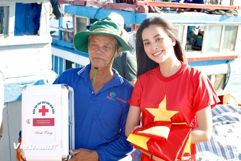 Hoa hậu Tiểu Vi trao cờ và tủ thuốc cho 1 chủ tàu. (Ảnh: Tùng Lâm/Vietnam+)