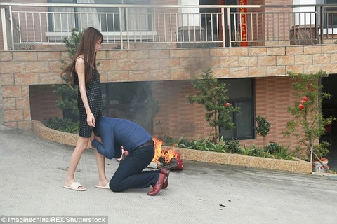 Anh chồng quỳ xuống ôm chân vợ trong một bức ảnh đang gây xôn xao dư luận Trung Quốc (Nguồn: Daily Mail)